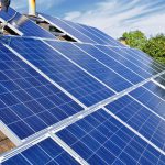 Man working on solar panels on a roof