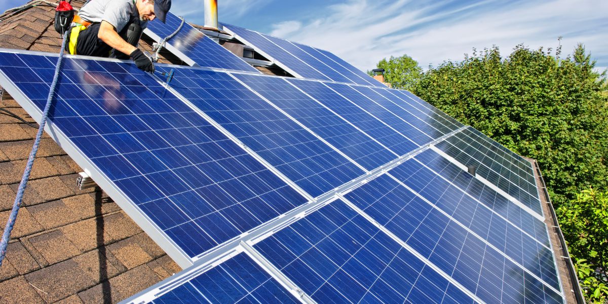 Man working on solar panels on a roof